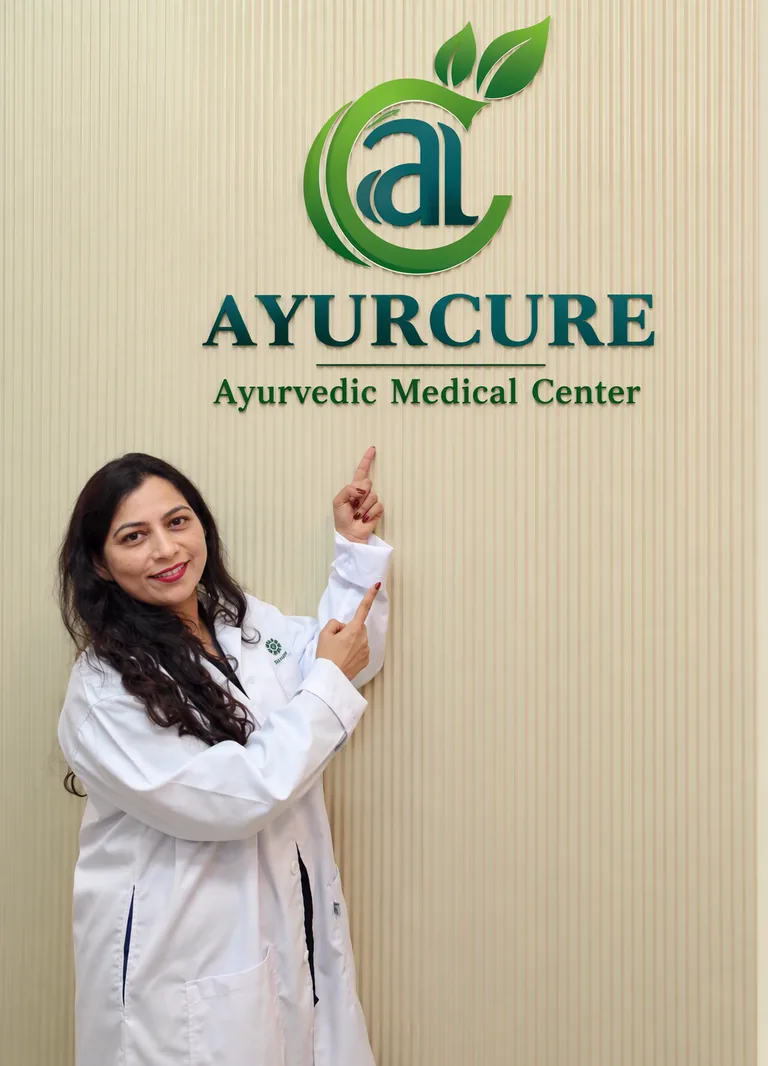 Dr. Seema at Ayurcure Ayurvedic Medical Center beneath the Ayurcure clinic logo